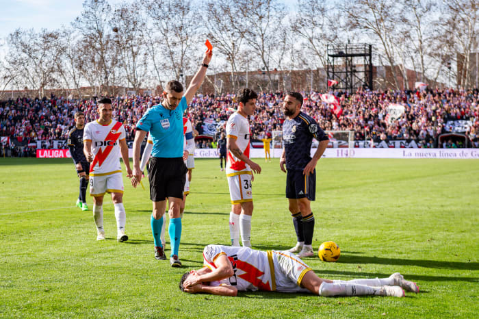 Referee Alejandro Muniz pictured showing a red card to Dani Carvajal (right) after the Real Madrid defender lashed out at Rayo Vallecano midfielder Kike Perez (bottom) during a La Liga game in February 2024